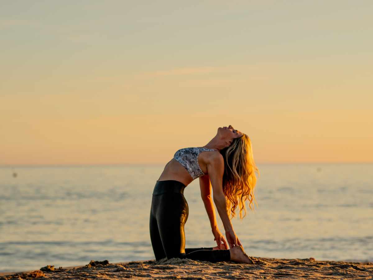 Jaime McFaden on beach yoga looking at sky